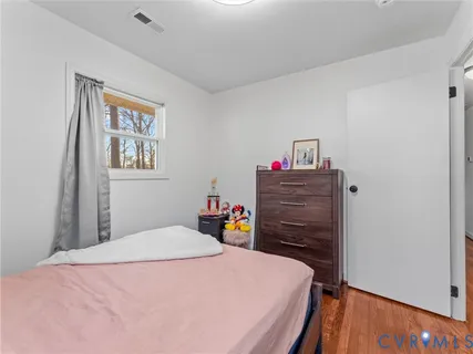 a bedroom with a bed a dresser and book shelf