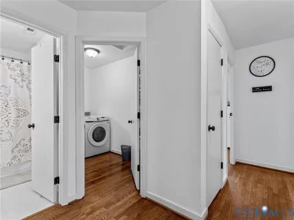 a view of a hallway with wooden floor and closet