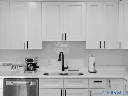 a kitchen with stainless steel appliances granite countertop white cabinets and a sink