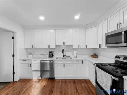 a kitchen with a sink stove top oven and cabinets