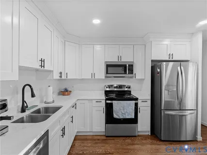 a kitchen with refrigerator a microwave a sink and cabinets