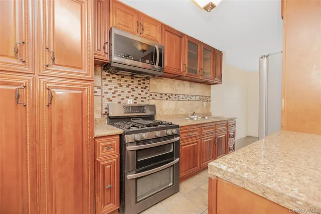 a kitchen with stainless steel appliances granite countertop a stove microwave and cabinets