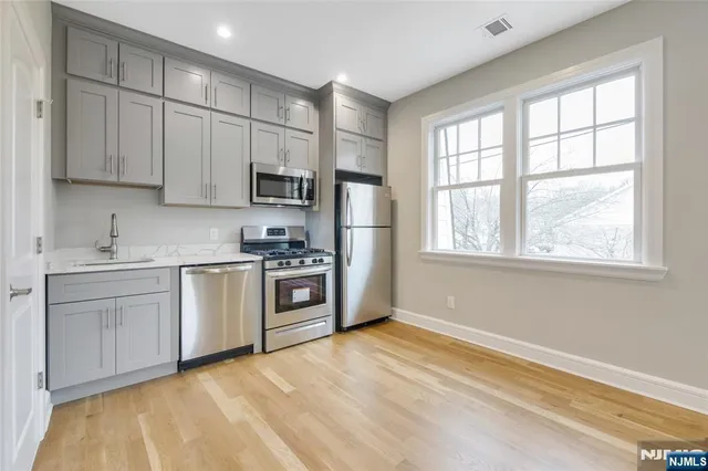 a kitchen with stainless steel appliances granite countertop a stove a sink and a refrigerator