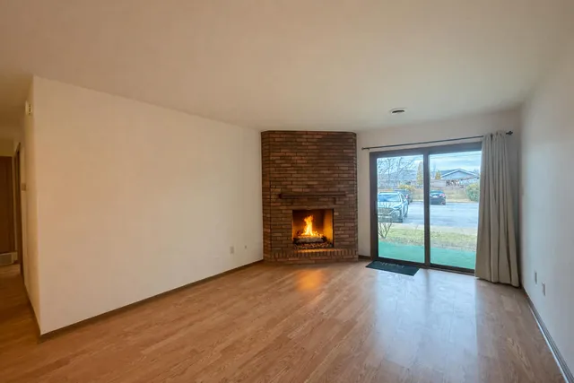an empty room with wooden floor and fireplace