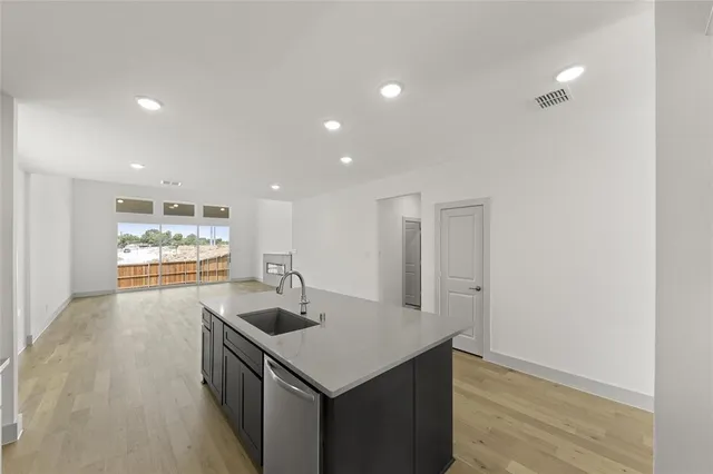 a kitchen with stainless steel appliances granite countertop a sink and a refrigerator