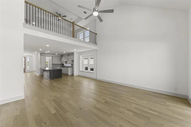 a view of an empty room and kitchen view