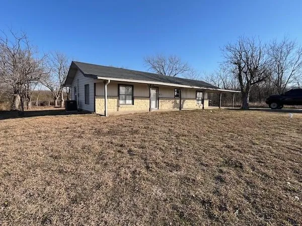 a front view of house with yard and trees around