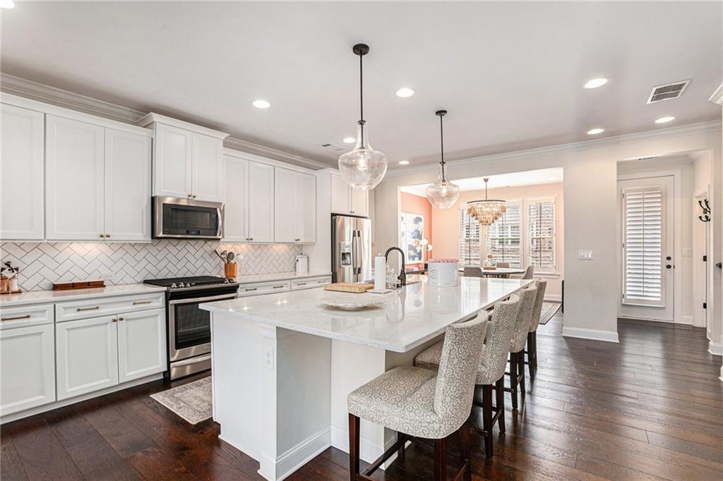 1438 Druid Manor Boulevard Atlanta, GA 30329 - Photo 12 of 31 a kitchen with stainless steel appliances granite countertop a stove top oven a sink dishwasher and a refrigerator with wooden floor