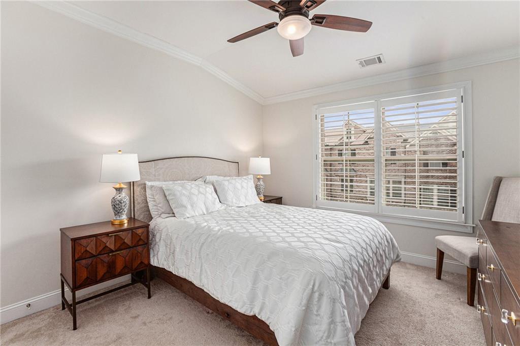 1438 Druid Manor Boulevard Atlanta, GA 30329 - Photo 20 of 31 a bedroom with a bed chandelier and a window