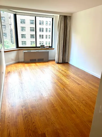a view of a room with wooden floor and a window