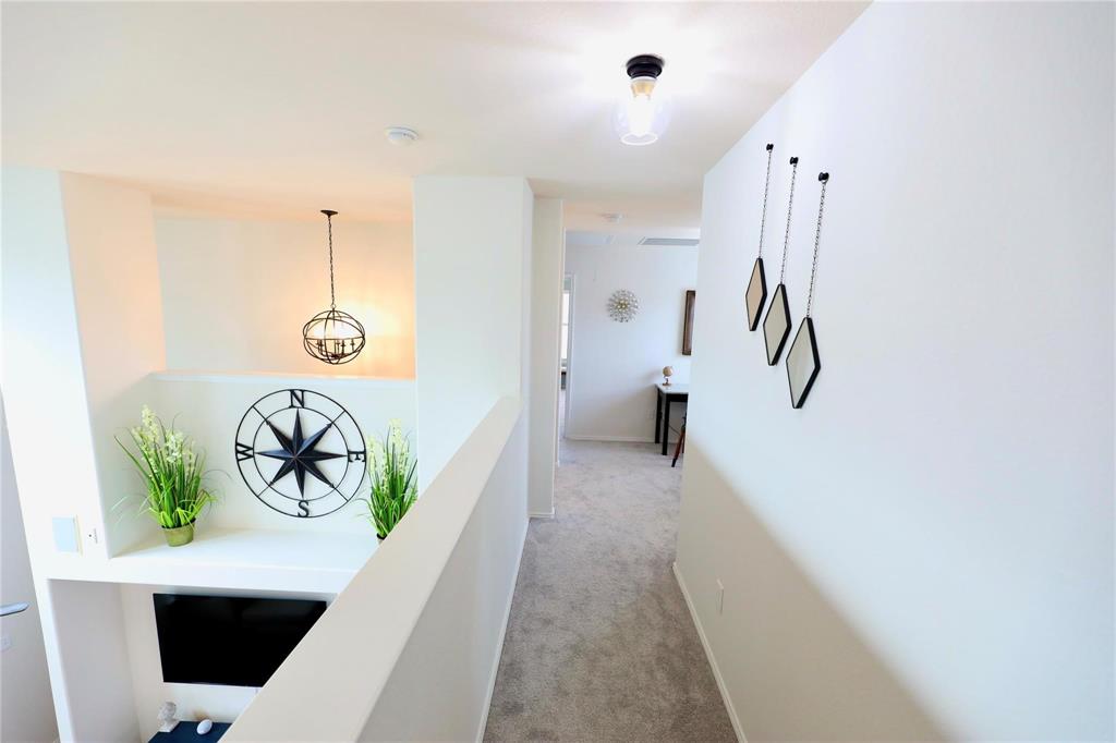 8404 Timberbrook Lane Dallas, TX 75249 - Photo 16 of 32 a hallway with a white walls cabinets a washer and dryer