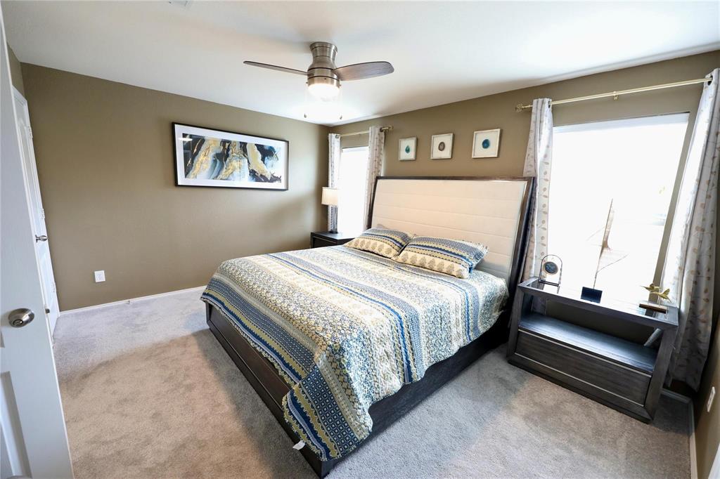 8404 Timberbrook Lane Dallas, TX 75249 - Photo 18 of 32 a bedroom with a bed and a large mirror