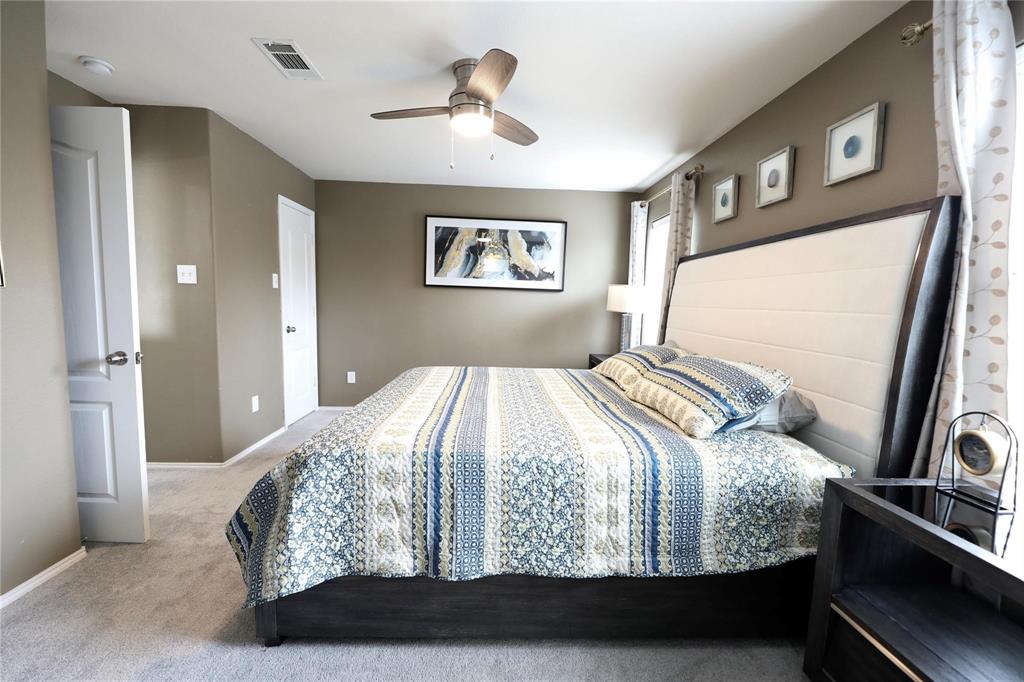 8404 Timberbrook Lane Dallas, TX 75249 - Photo 21 of 32 a bedroom with a large bed and a chandelier