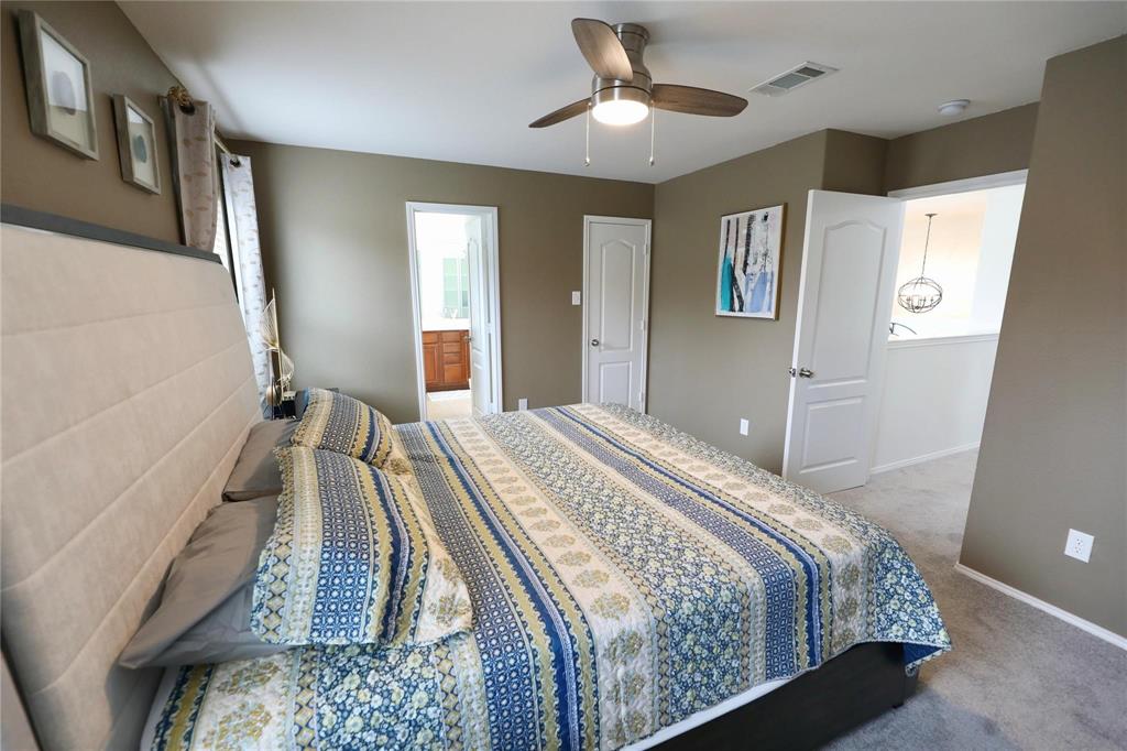 8404 Timberbrook Lane Dallas, TX 75249 - Photo 22 of 32 a bedroom with a large bed and a chandelier