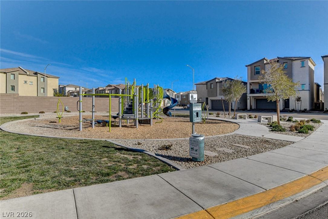 6924 Spicy Merlot Street North Las Vegas, NV 89086 - Photo 45 of 83 A neighborhood park with a vibrant playground, surrounded by modern homes and paved walkways.
