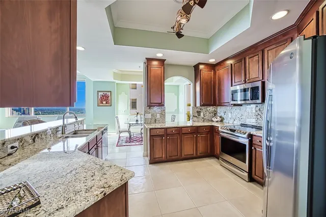 a kitchen with stainless steel appliances granite countertop a sink stove and refrigerator