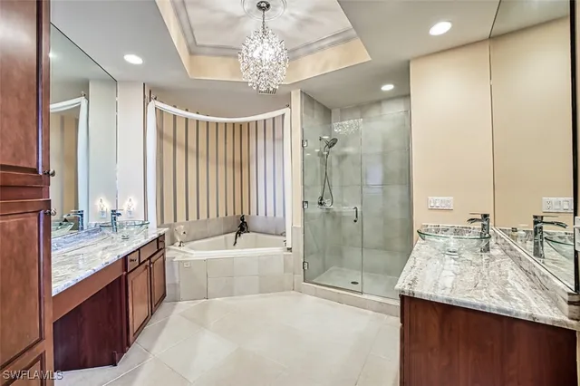 a bathroom with a granite countertop double vanity sink and mirror with shower