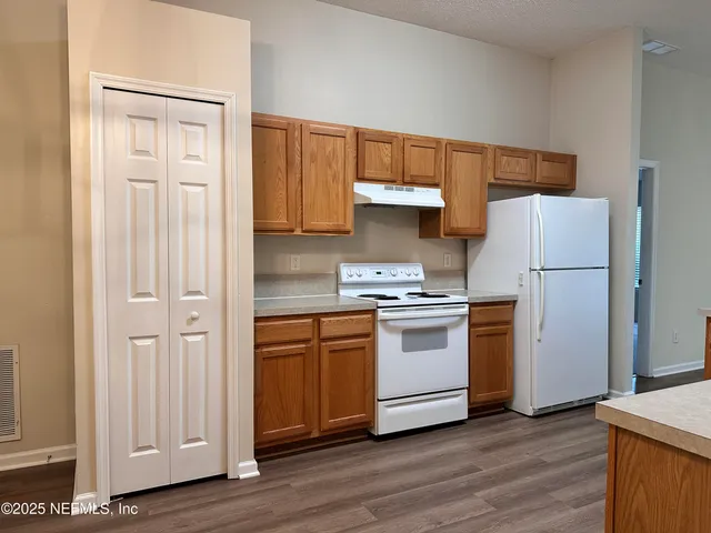 a kitchen with white cabinets and white appliances