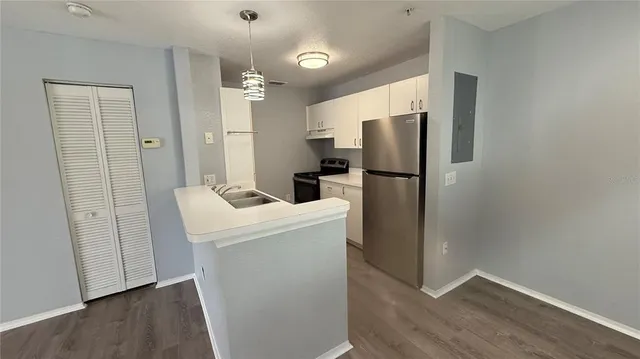 a kitchen with a refrigerator sink and cabinets