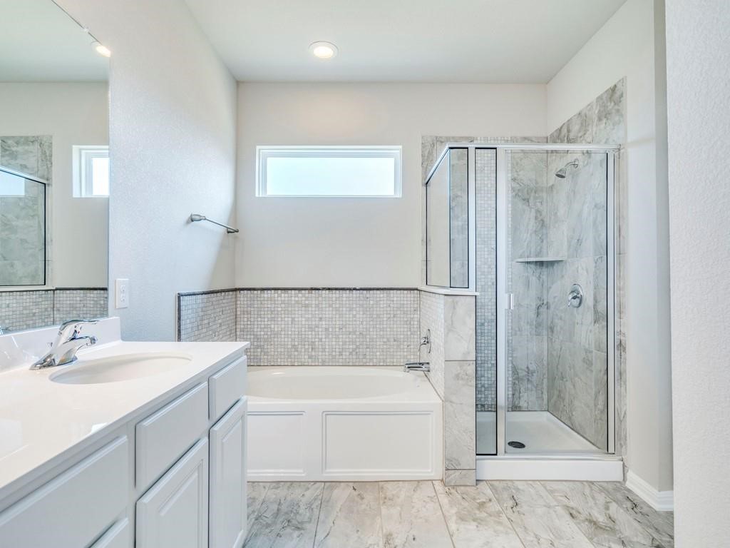 4210 Birdwatch Loop, Unit 2 Pflugerville, TX 78660 - Photo 17 of 31 Indulge in a primary bathroom featuring a spacious soaking tub and an elegant glass-enclosed shower.
