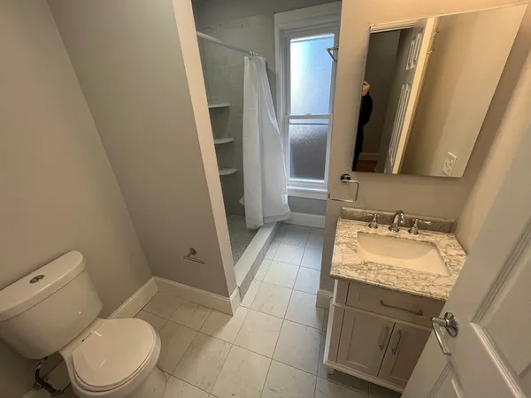 a bathroom with a granite countertop sink toilet and shower
