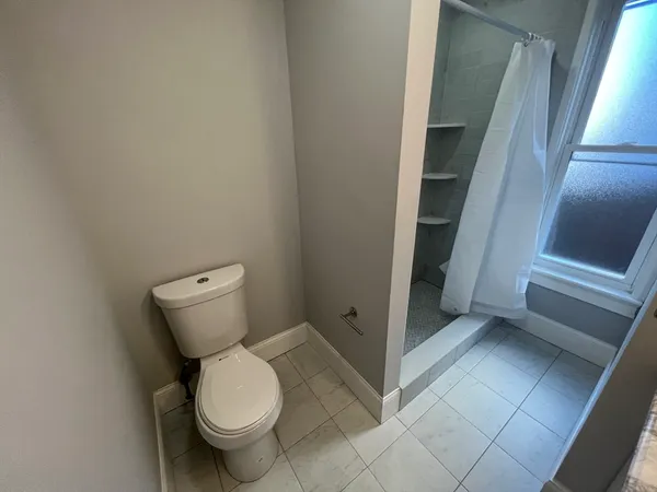 a bathroom with a toilet and a shower