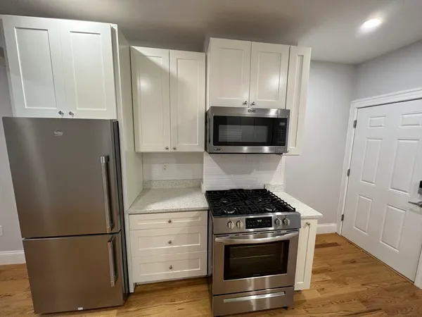 a kitchen with stainless steel appliances a refrigerator stove and microwave
