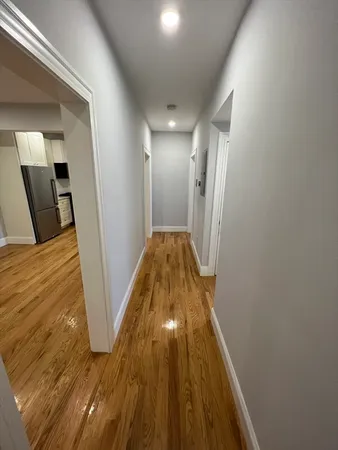 a view of a hallway with wooden floor
