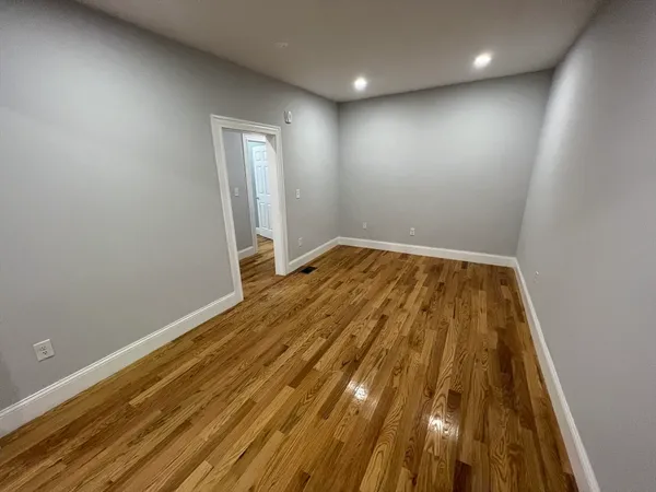 an empty room with wooden floor and closet