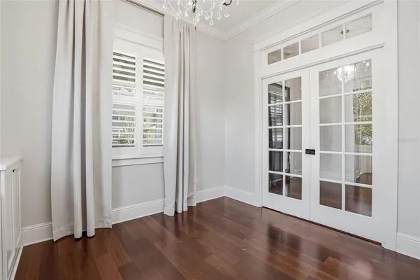 a view of a livingroom with wooden floor a ceiling fan and windows