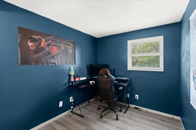 a view of a workspace with furniture and a window