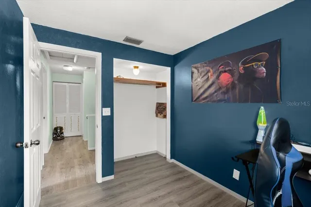 a view of a hallway with wooden floor and closet