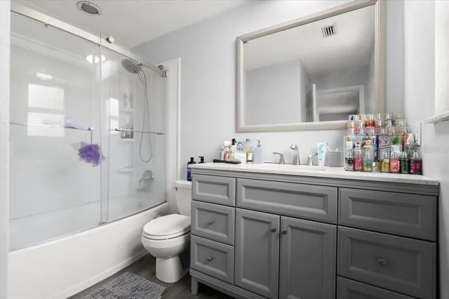 a bathroom with a shower sink vanity mirror and toilet