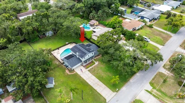 an aerial view of a house with a garden and swimming pool