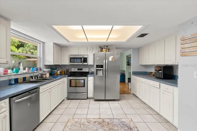 a kitchen with stainless steel appliances kitchen island granite countertop a sink and cabinets