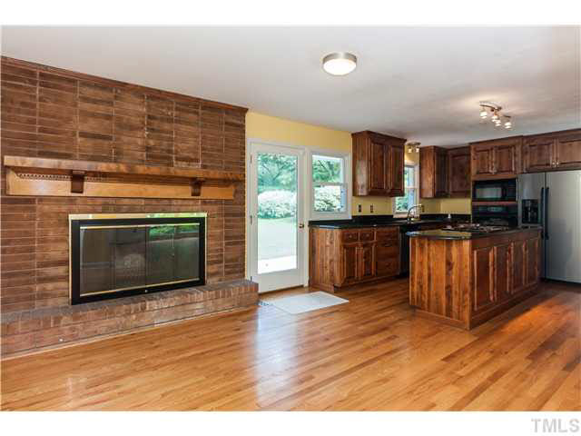 912 Macon Place Raleigh, NC 27609 - Photo 3 of 14 a kitchen with stainless steel appliances wooden cabinets and a stove top oven