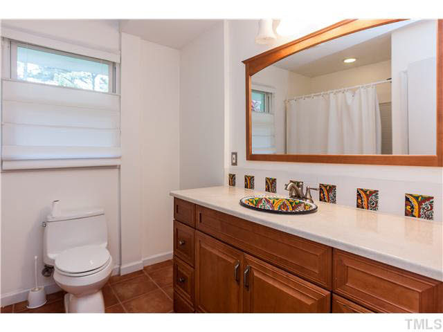 912 Macon Place Raleigh, NC 27609 - Photo 6 of 14 a bathroom with a toilet a sink a vanity and mirror