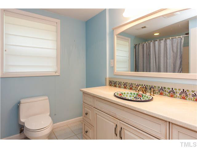 912 Macon Place Raleigh, NC 27609 - Photo 9 of 14 a bathroom with a sink a toilet and a mirror