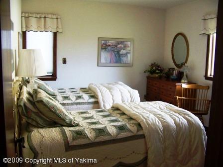 168002 McCreadie Road Grandview, WA 98930 - Photo 8 of 34 a bedroom with a bed a mirror and a window