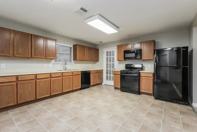 a kitchen with stainless steel appliances granite countertop a stove a sink and a refrigerator