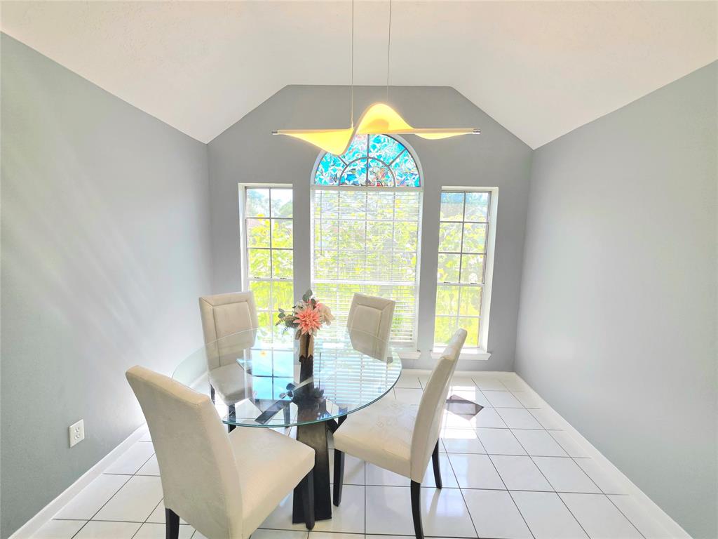 13618 Sablegrove Lane Houston, TX 77014 - Photo 9 of 30 a view of a dining room with furniture a chandelier and a large window