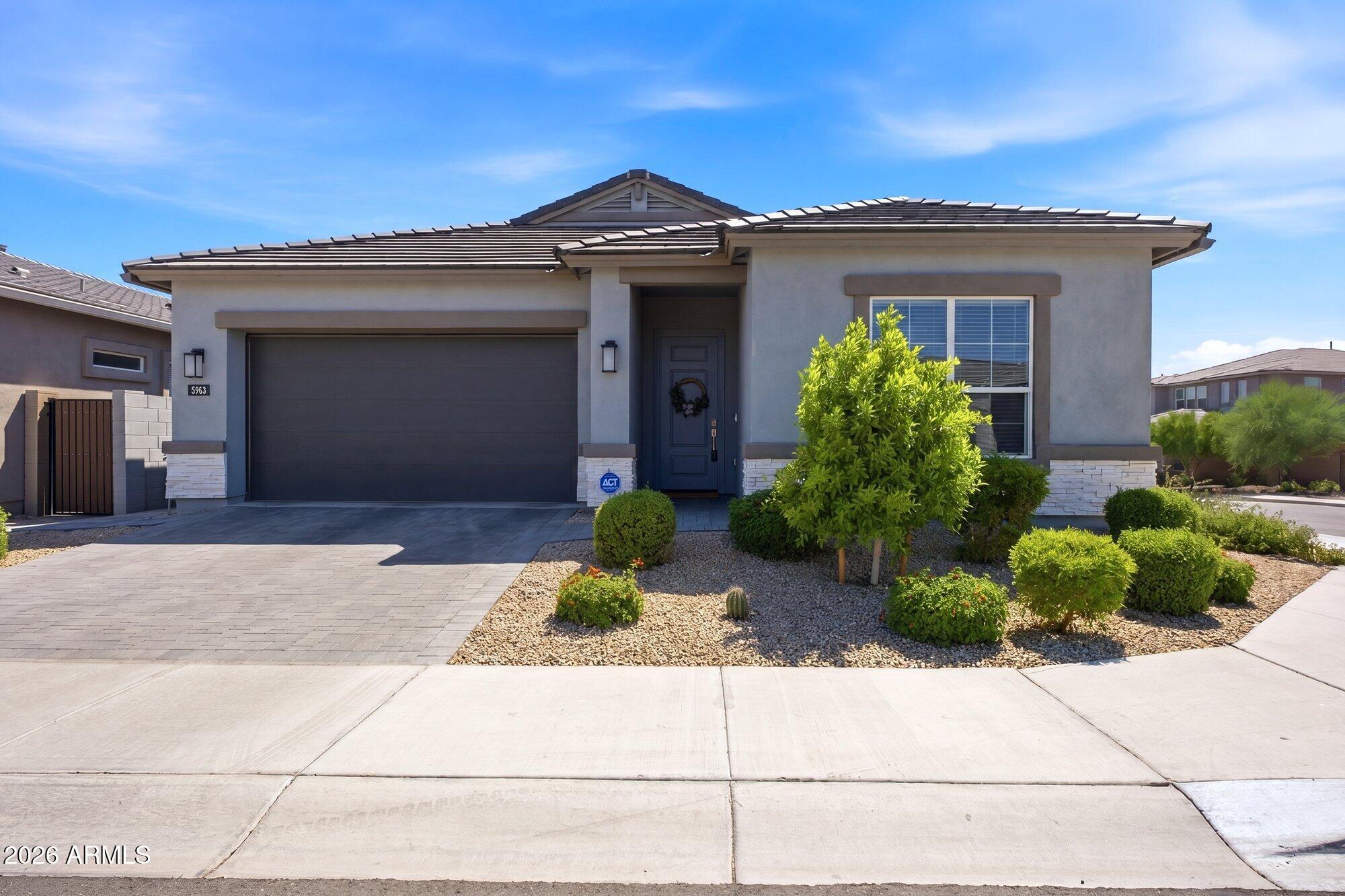 5963 East Lone Cactus Road Phoenix, AZ 85054 - Photo 2 of 22 a front view of a house with a yard and garage
