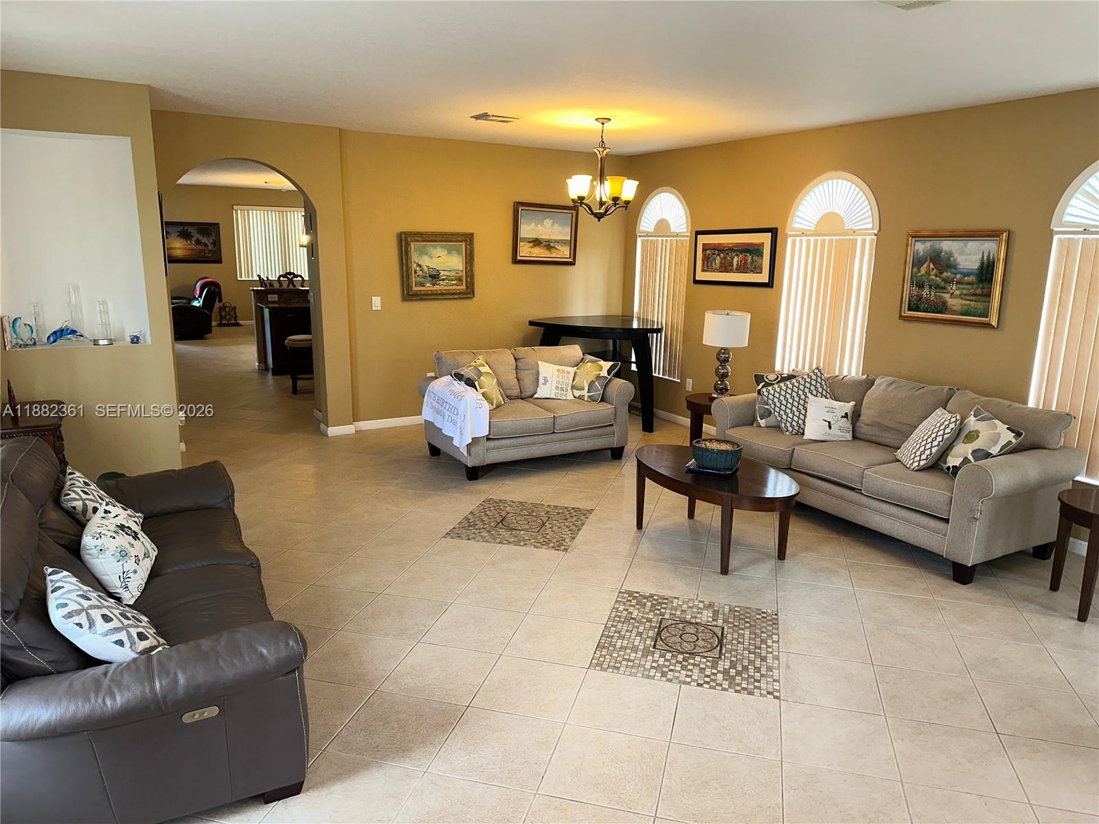 13986 Southwest 276th Way Homestead, FL 33032 - Photo 11 of 32 a living room with furniture and a chandelier