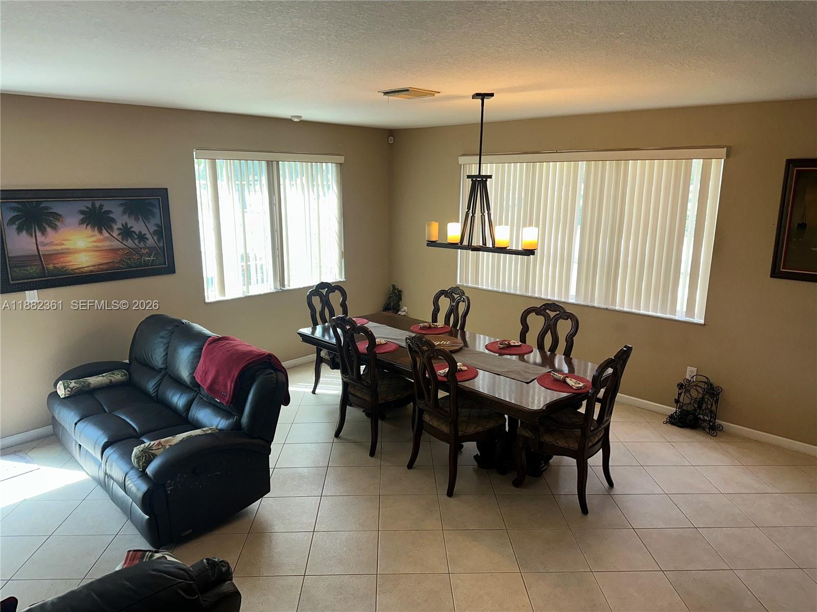 13986 Southwest 276th Way Homestead, FL 33032 - Photo 16 of 32 a living room with furniture two windows and a flat screen tv