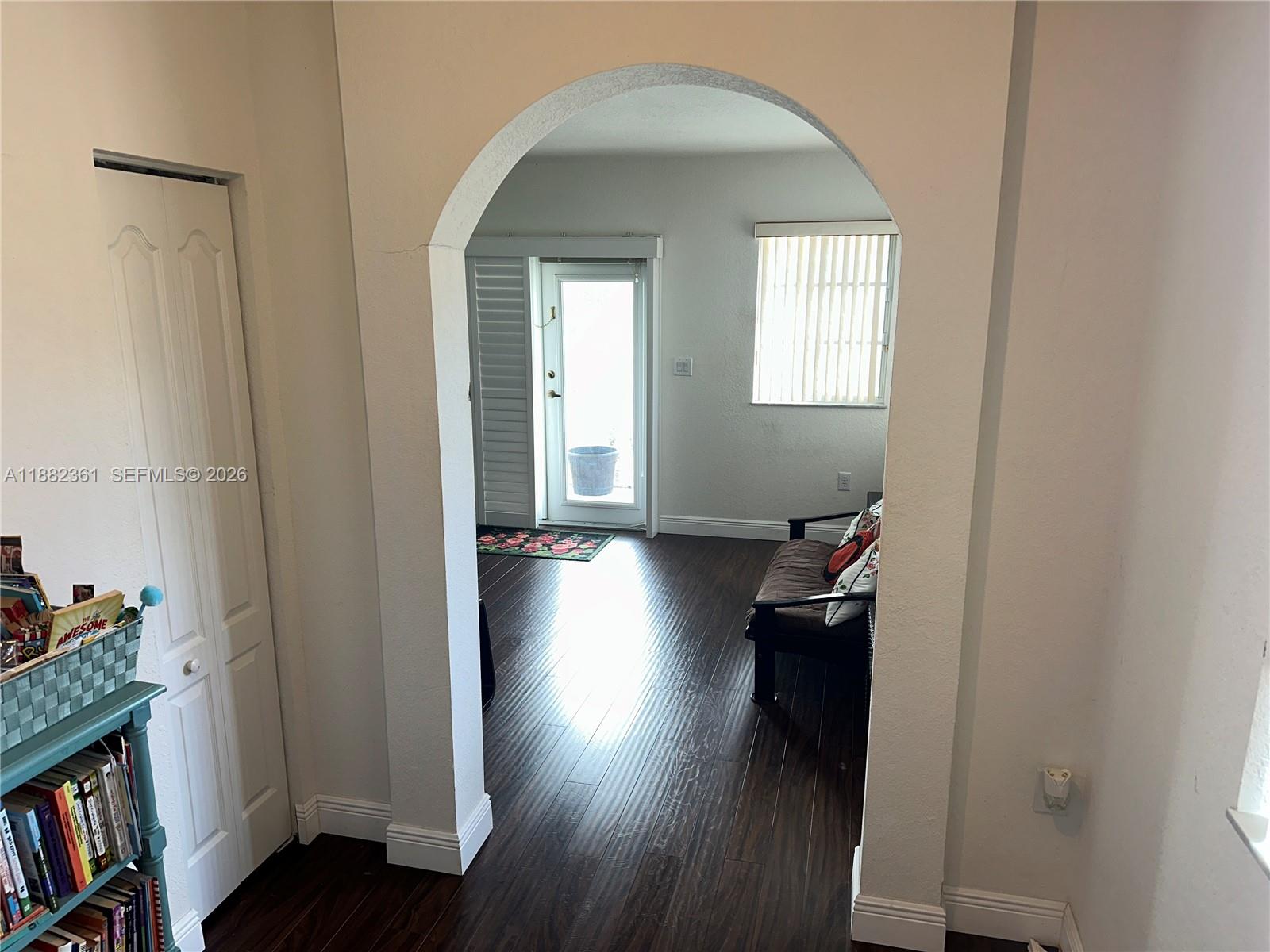 13986 Southwest 276th Way Homestead, FL 33032 - Photo 20 of 32 a view of a hallway and wooden floor and a livingroom with furniture