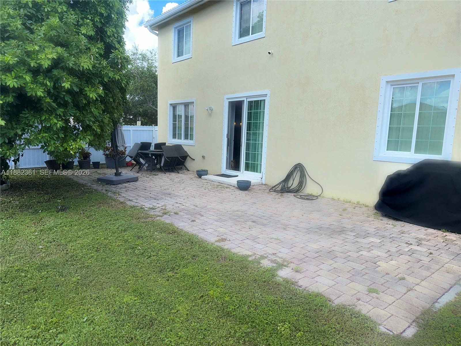 13986 Southwest 276th Way Homestead, FL 33032 - Photo 27 of 32 a view of a backyard with table and chairs and a barbeque