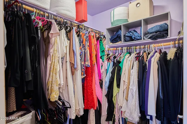 a view of walk in closet with clothes