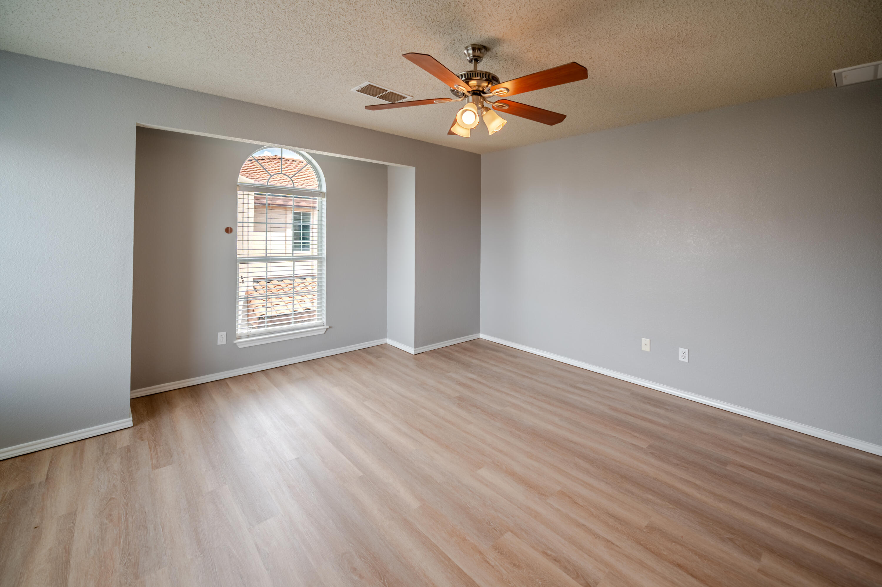 2111 Main Street, Unit 1 Lubbock, TX 79401 - Photo 25 of 36 an empty room with wooden floor chandelier fan and windows