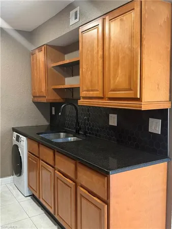 a kitchen with granite countertop a sink a stove and cabinets