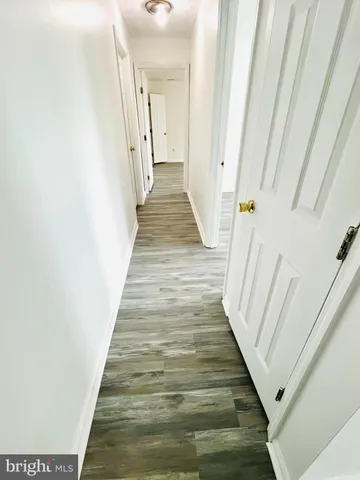 a view of a hallway with wooden floor and entryway
